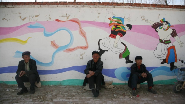 在辽宁省朝阳市喀左县小营村，留守老人们聚坐在墙根下。