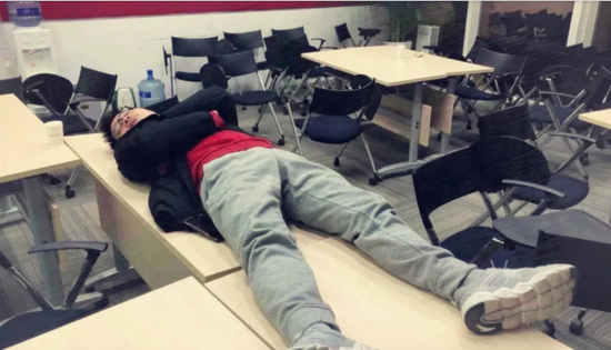 一位同学躺在桌子上睡觉，被无情偷拍