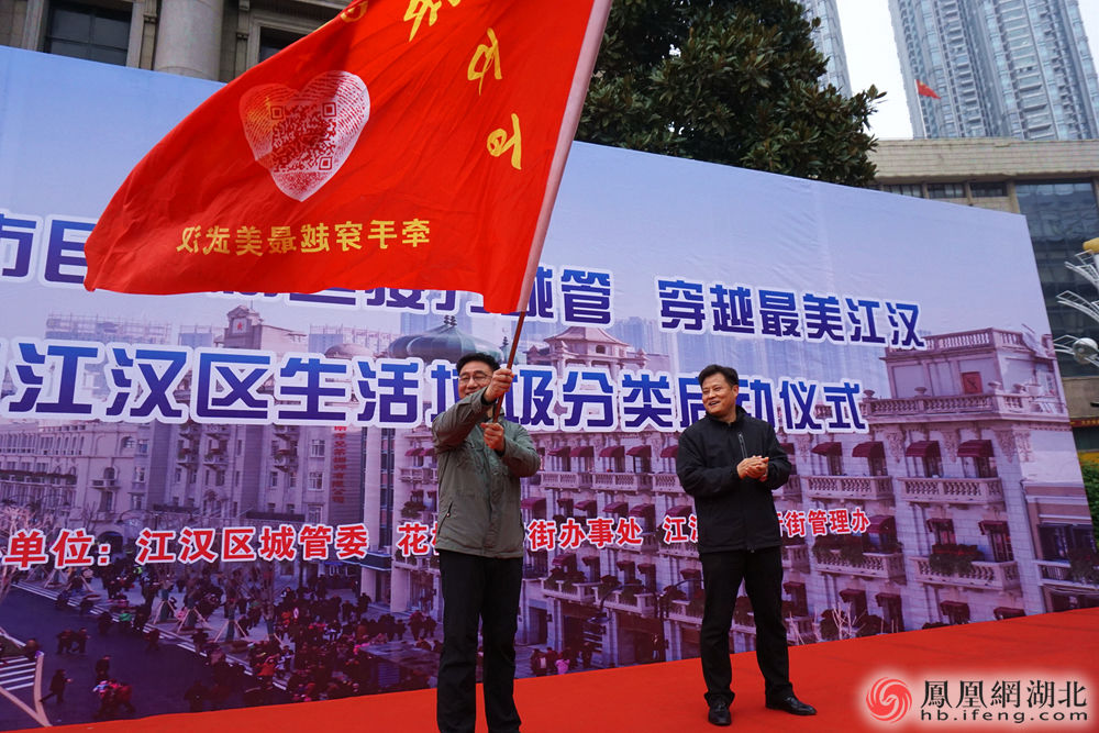 江汉区城管委主任熊楠为活动摇旗 摄影:熊丹丹