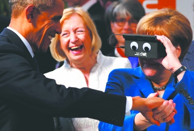 25日，在德国汉诺威，德国总理默克尔（右）和美国总统奥巴马在汉诺威工业博览会上体验虚拟现实眼镜。