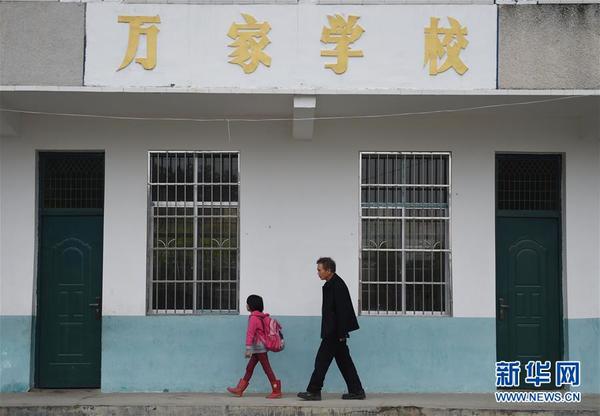 4月27日,放学后彭逸(前)和李吹明从教室前走廊经过。新华社记者 李尕摄