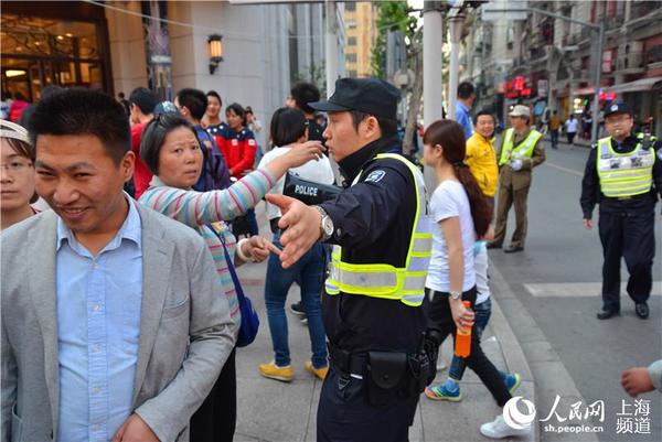 4月30日15时30分,南京东路江西中路路口,距离外滩500米,为避免人群对流,所有去往外滩方向的行人被疏导至马路右侧行进。(周茹芸摄)