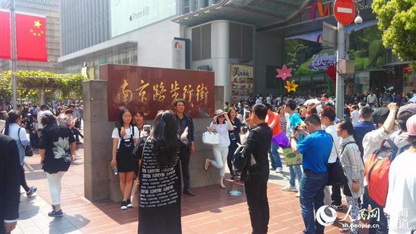 5月1日上午,南京路步行街,街上人头攒动,来自各地的游客们纷纷在步行街的牌子前合影留念。(邬迪摄)