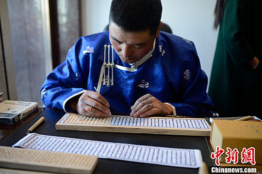 5月5日,艺人展示蒙文雕版木刻印刷技艺。中新社记者 刘文华 摄
