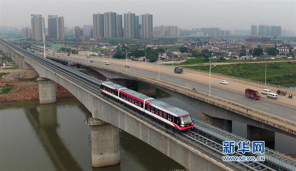 　　 上线试运营的长沙磁浮快线驶过浏阳河（5月6日摄）。新华社记者李尕摄