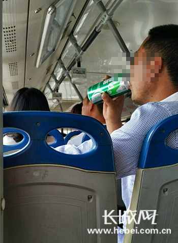 男子在公交車上邊吃韭菜包子邊喝啤酒,。圖片由網(wǎng)友“茶瓶兒”提供
