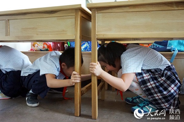 “地震”来了,学生们在老师的指挥下紧急避险。