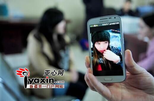 图为：5月11日，乌鲁木齐市公安局高新区（新市区）分局安宁渠派出所，手机上为张女士用来欺骗网恋“男友”的照片。