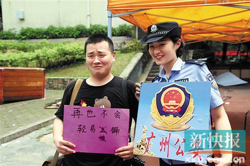 ■警花在暨大校园内发“诈骗”短信,一名学生“上当”后手持写着“再也不会轻易被骗”的纸牌与警花合影。 通讯员供图