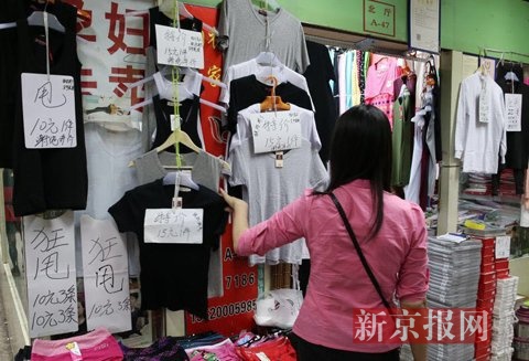 　　一家服装店打出狂甩的纸牌子。