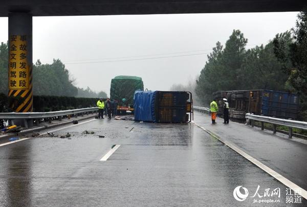 两辆货车因雨天路滑发生事故，侧翻在高速公路上。