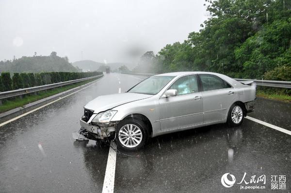 一辆轿车在雨天发生交通事故,横在高速公路行车道上。