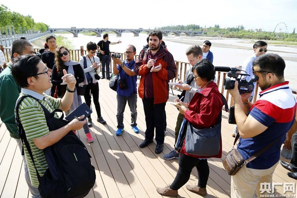 中外记者在伊犁河景观带采访