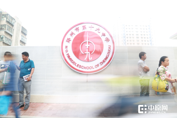 十九中考点外等候的家长和匆匆路人.