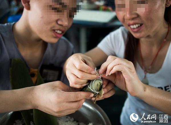 端午节前夕，江西省未管所邀请百名母亲走进监狱和自己的孩子一起包粽子，庆佳节。（李斌/摄）
