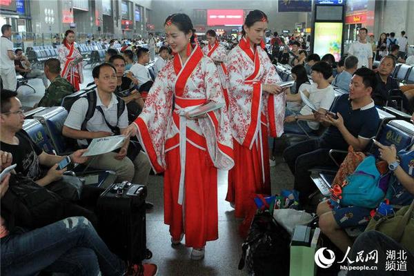 身着汉服的工作人员在候车室向旅客发放中国古代文明诗词和文明旅游出行的宣传页。刘卫兵 摄