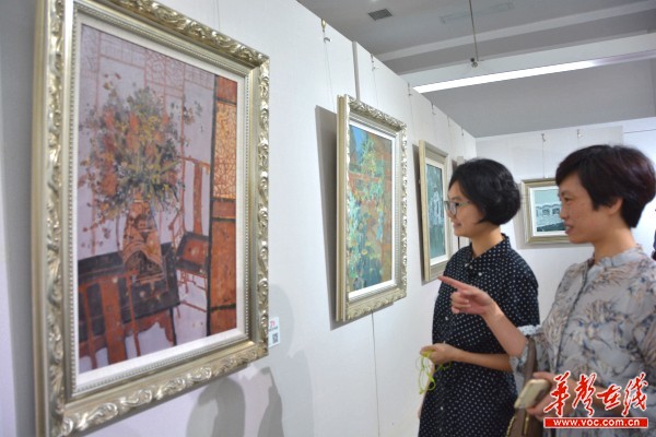 图为嘉宾在观赏画作