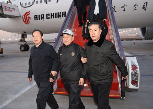 2014年12月22日，王国强（中）回国投案自首，到达首都机场。中央纪委监察部网站 李放摄