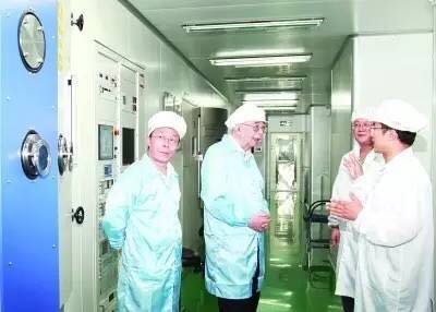 2013年，张存浩（左二）与金云奇、桑凤亭等人在实验中进行交流。 图片来源：经济日报