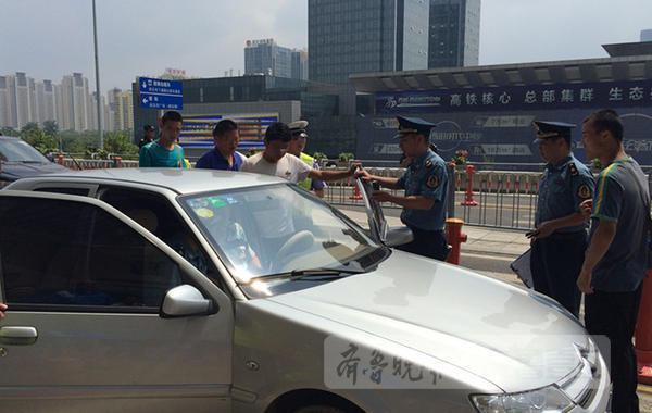 客管中心执法队员和交警对可疑车辆进行盘查。