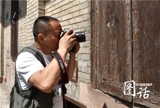 当地摄影师张超云在拍摄老粮站。