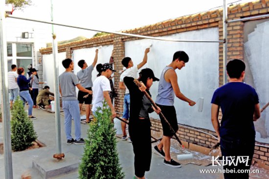 河北地质大学艺术设计学院扶贫小分队进行文化墙绘。 胥文燕 摄