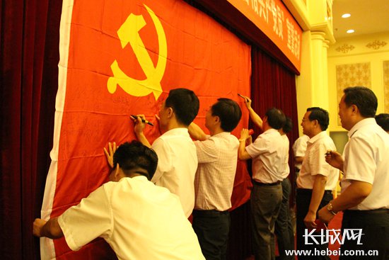 省委宣传部机关党员在党旗上签字。 长城网 张欣 摄