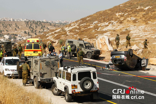 　　当地时间2016年7月1日，约旦河西岸一名巴勒斯坦枪手向一辆汽车开火导致翻车，一名以色列人死亡，三名亲属受伤。图为以色列警方和急救人员在车祸现场。图片来源：视觉中国