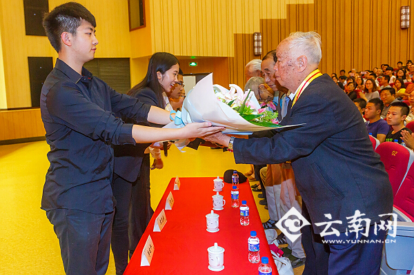 新入党学生党员代表向建国前老党员代表献花。