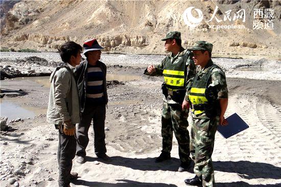 民警在底雅乡沙石场向工人了解施工情况，叮嘱施工人员要做好安全防护措施。