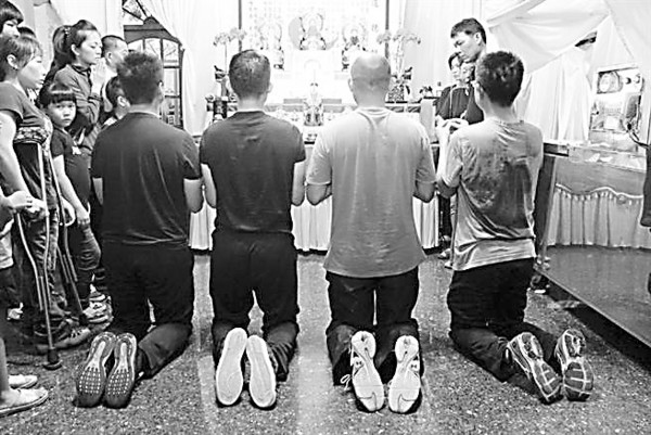 4名军士官在死者灵堂上香下跪。