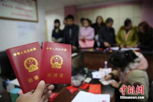资料图：在某婚姻登记处，新人在展示刚领取的结婚证书。 兰自涛 摄