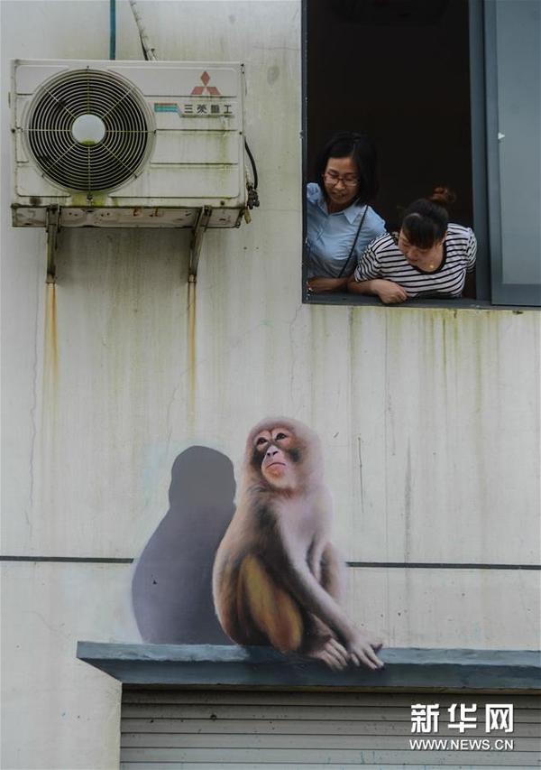 　　7月13日，浙江省长兴县北汤村村民在观看窗户下的3D画。