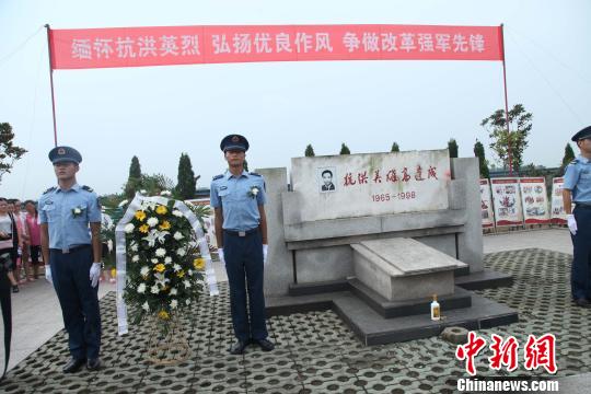 图为，部队官兵和烈士亲属向高建成纪念碑敬献花篮　张欢　摄