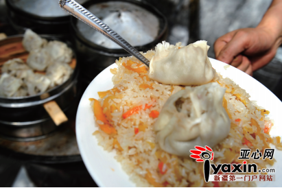 昨天上午，西后街司马依餐厅，店员为顾客盛上素抓饭和薄皮包子。 亚心网记者 豆兴军 摄