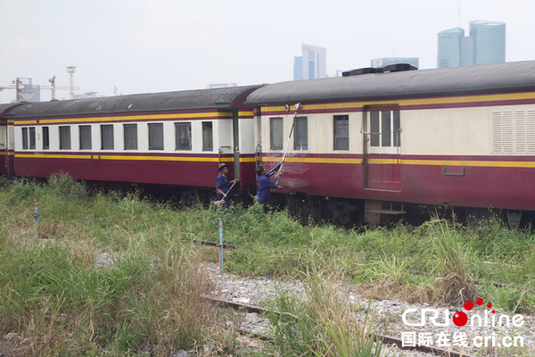 列车运行途中，有工人在清洁泰国的旧火车，泰国原有的火车老旧，很多还没有空调