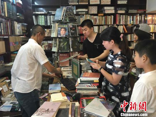 顾客等待店员蔡文强盖上“晓风书屋”印鉴。　林春茵 摄