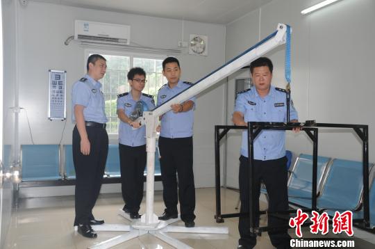 白云志（左一）与团队成员示范使用“水中尸体打捞工具”　程景伟　摄
