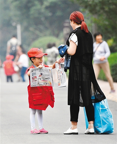 小报童街头卖报为残疾人献爱心