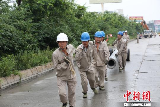 圖為龍巖供電公司搶修隊員正在人工搬運電桿。　鐘曉鋒 攝
