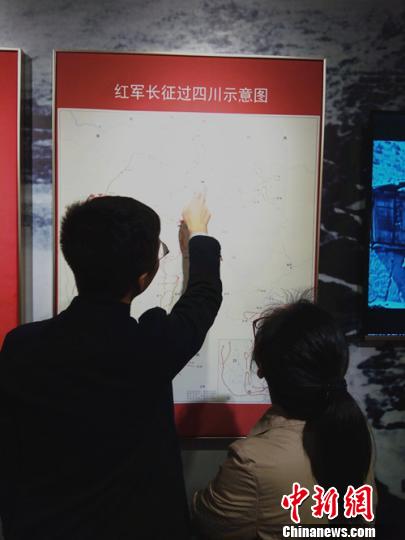 参观者正在仔细查看展示的红军长征路线图。　王哲 摄