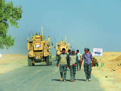 18日，伊拉克政府军士兵行进在摩苏尔市南部盖亚拉镇前线。