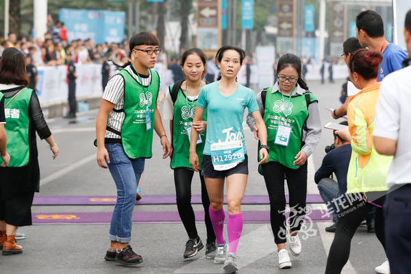 选手冲过半程终点,志愿者马上前来搀扶。记者 石涛 摄