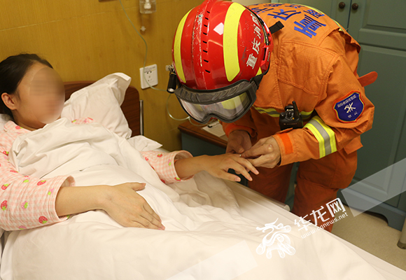 消防战士赶到医院帮孕妇摘取卡在手指上的钻戒。 两江新区消防支队供图 华龙网发
