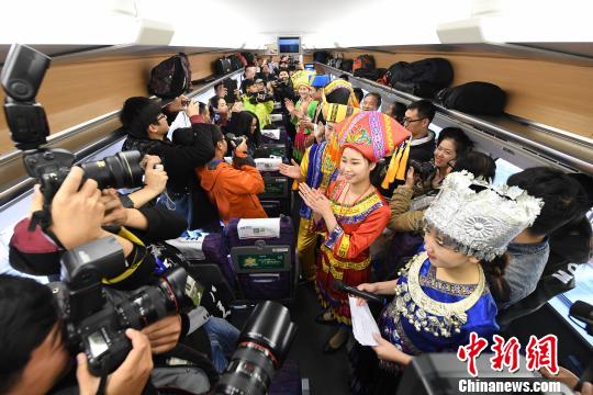 12月28日，在由南宁东开往昆明的D4203次动车上，身穿民族服装的工作人员在演唱山歌庆祝列车开通。　胡雁　摄