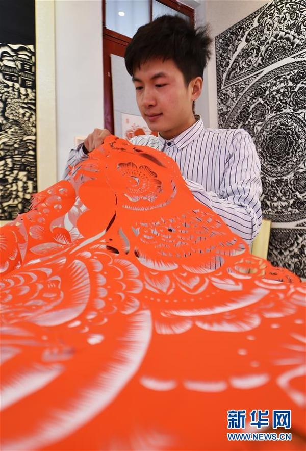 　　12月29日，畅杨杨正在创作剪纸作品《百鸡图》。
