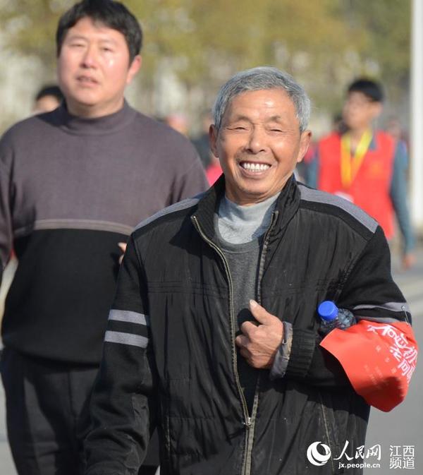 79岁的李大爷(右)参加徒步迎新活动,步伐稳健不逊年轻人。