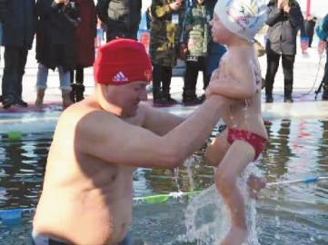 奥列格抱着不到3岁的儿子下水冬泳 新文化记者 杨威 摄
