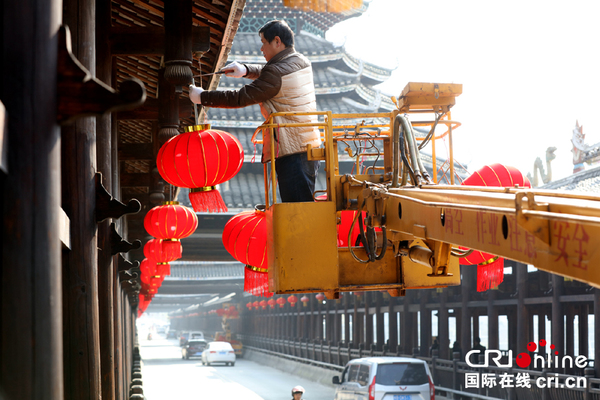 1月24日，在三江风雨桥上，工人正在悬挂灯笼。（摄影：吴练勋）