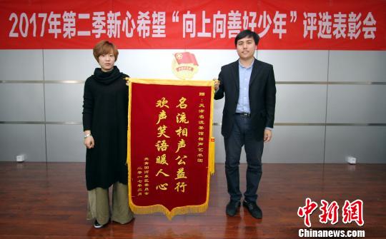 天津名流茶馆相声艺术团代表(左)接受锦旗。张道正 摄